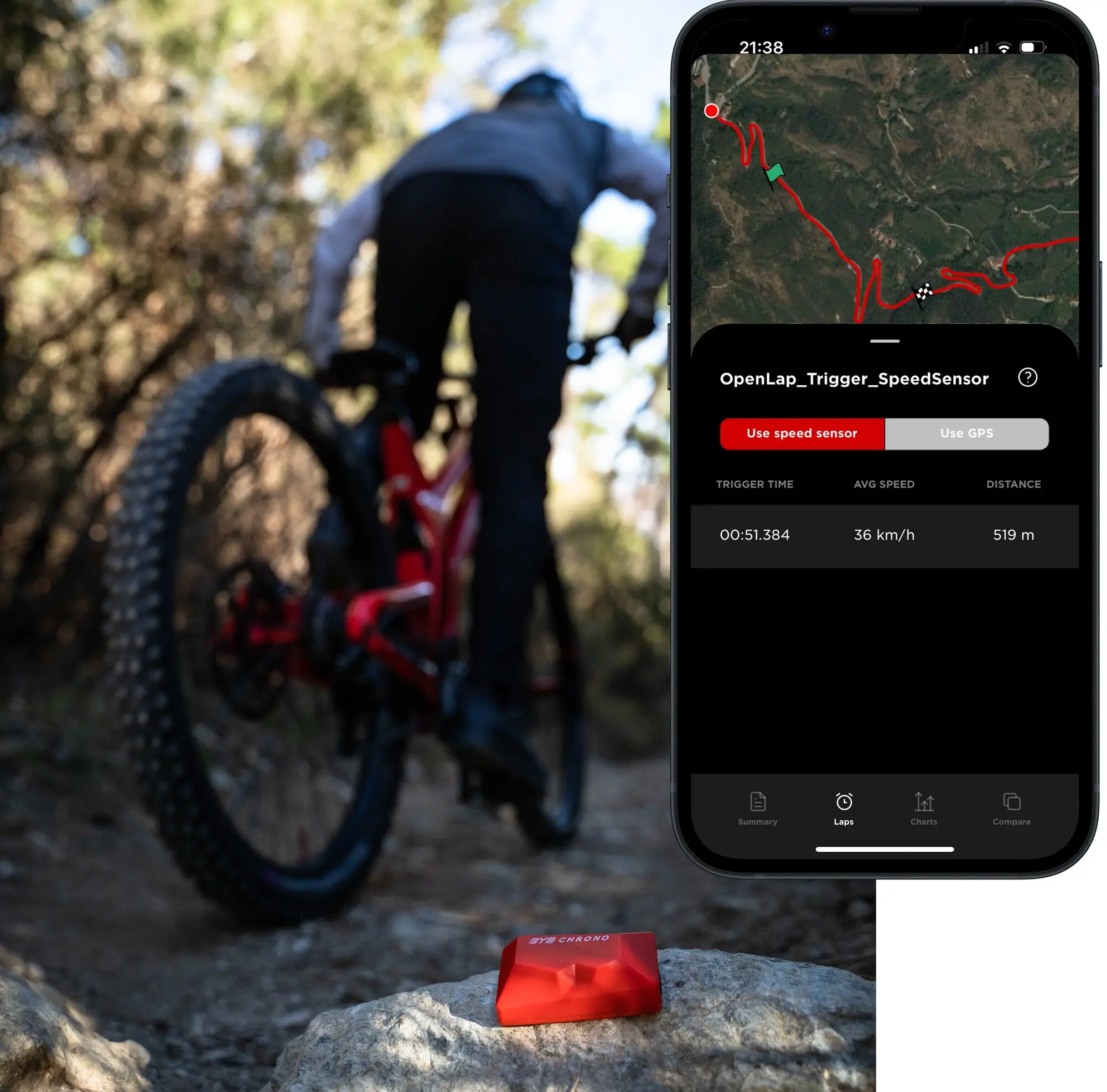 A red BYB Chrono coded trigger sitting on a rock beside a trail, with a rider riding away up the track and the app showing the lap it timed: 00:51.384 over 519 metres.