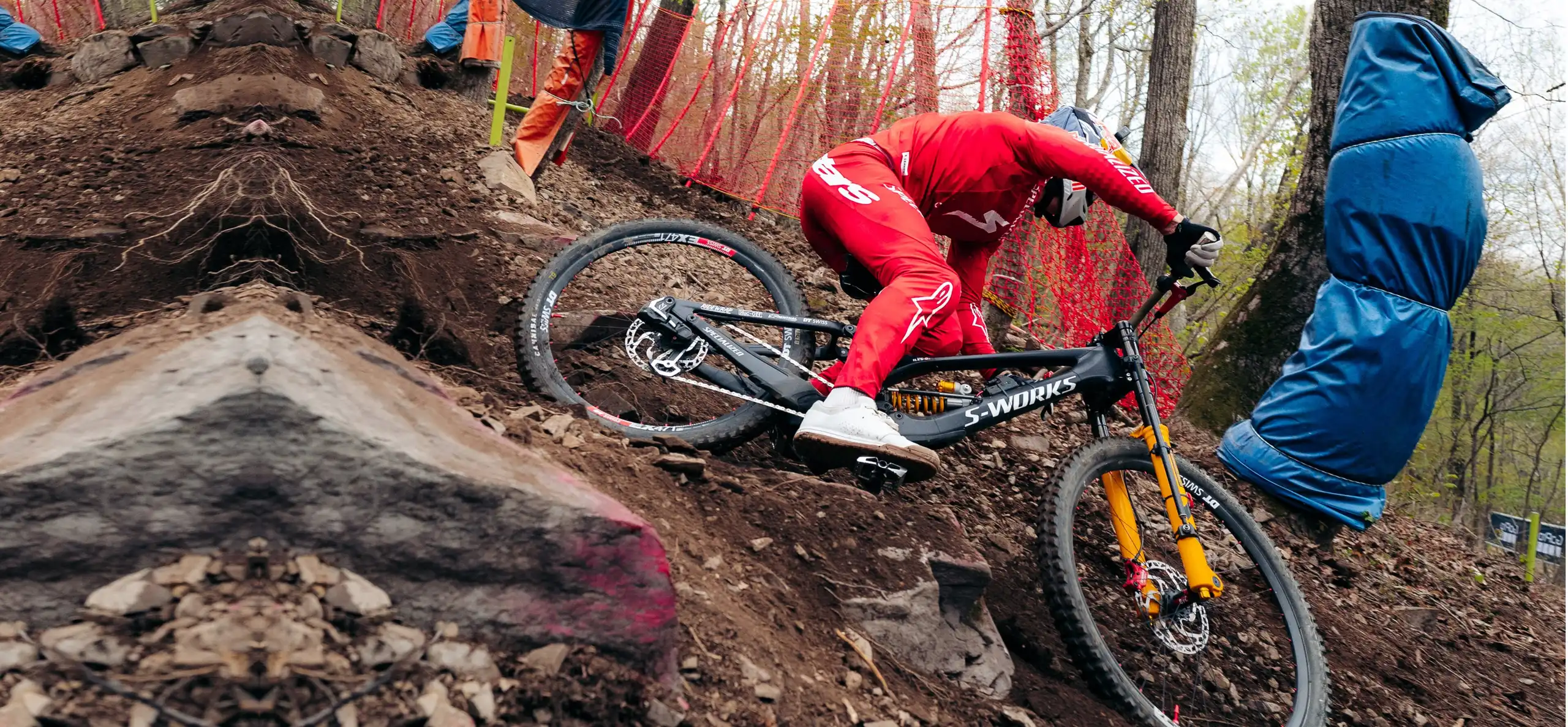 Finn Iles dropping into a steep rock chute on a Specialized downhill bike, with BYB sensors on the fork and the acquisition unit on the frame.