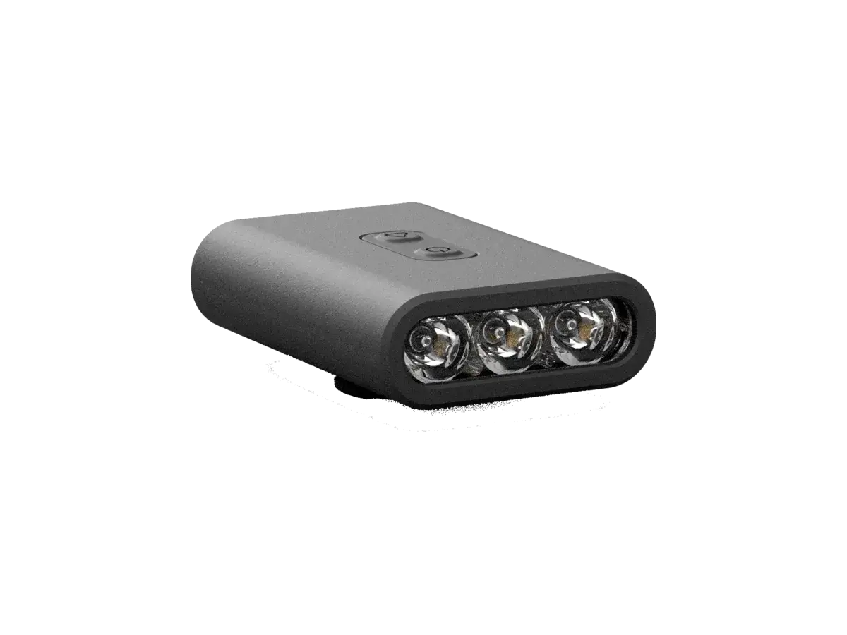 The BYB Focus bike light at three-quarters, unlit: a wide low body in dark grey with three lenses set in a row across the front and two buttons on the top face.