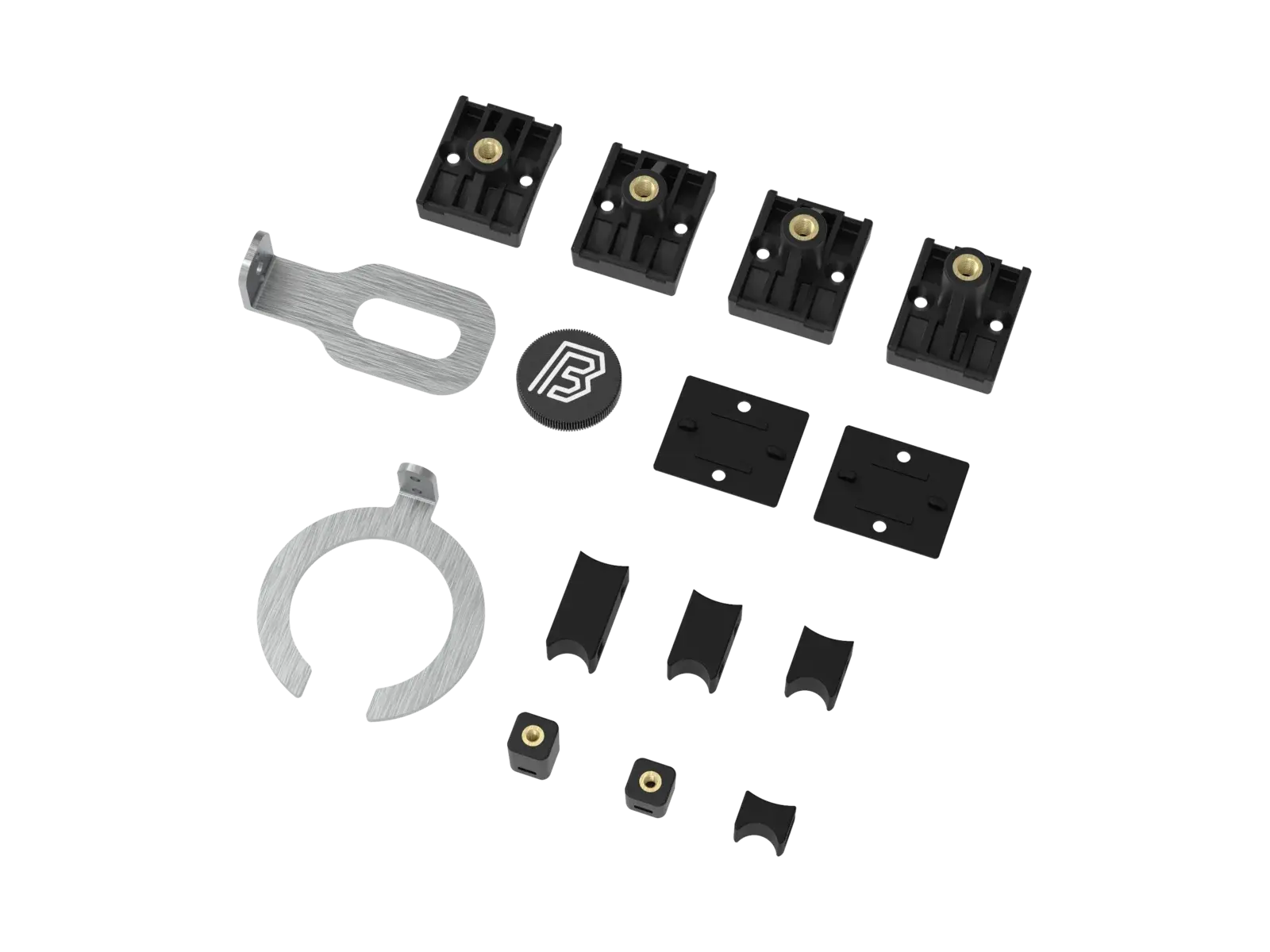 The MTB mountings full kit laid out flat: four black plastic fork mountings with brass inserts, two flat anti-slip pads, a slotted steel fork bracket, a BYB-marked aluminium fork cap, a C-shaped steel shock bracket, and six small plastic shock mountings.