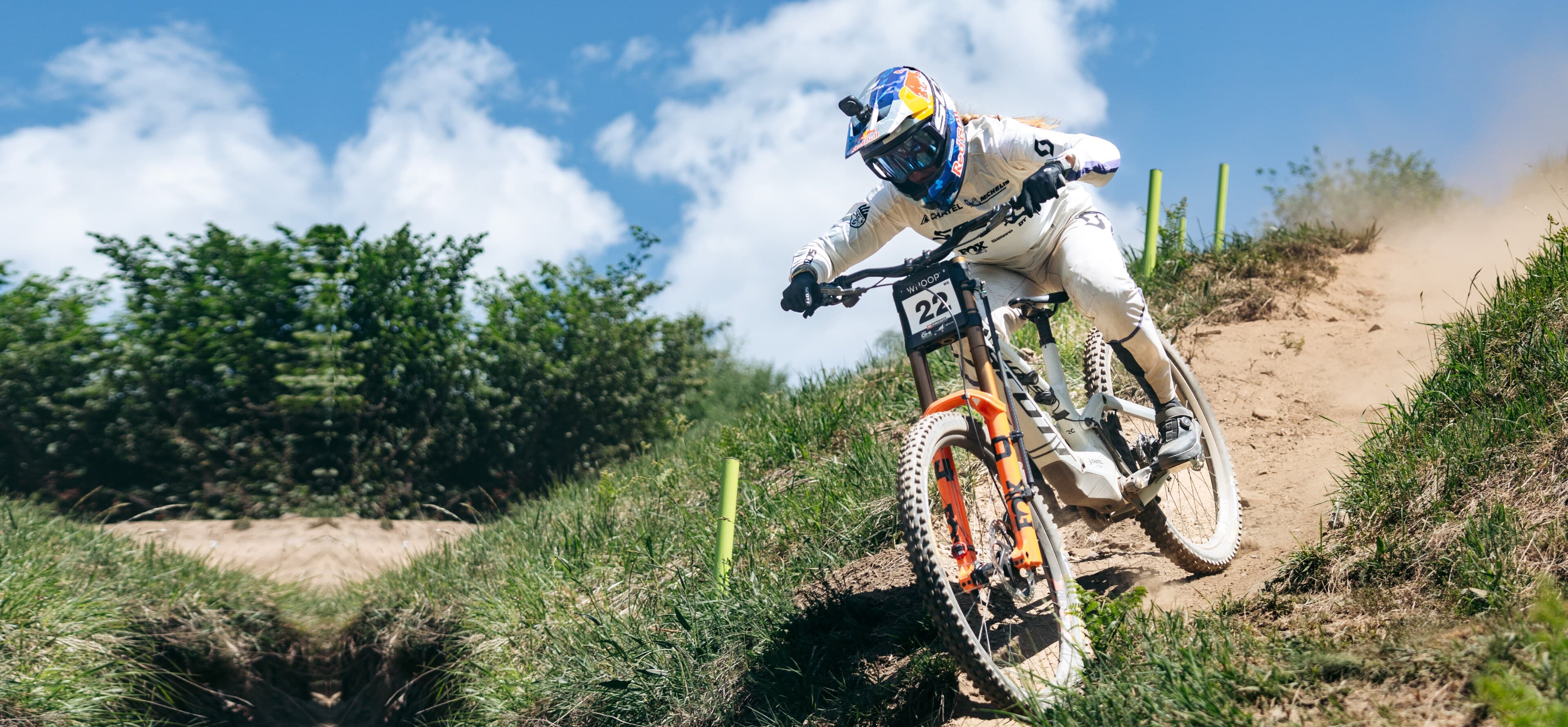 A downhill racer cornering through a dry, dusty berm during practice at a UCI Downhill World Cup round in Loudenvielle, France.