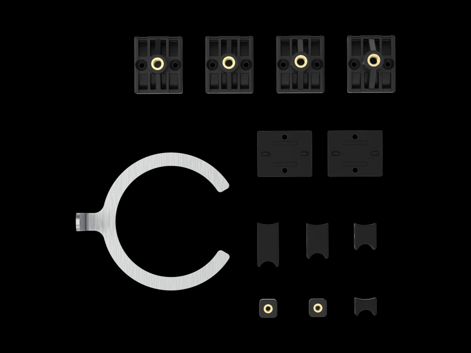 The MX mountings full kit laid out flat: four black plastic fork mountings with brass inserts, a slotted steel fork bracket, flat anti-slip pads, a C-shaped steel shock bracket and a set of curved plastic shock mountings.