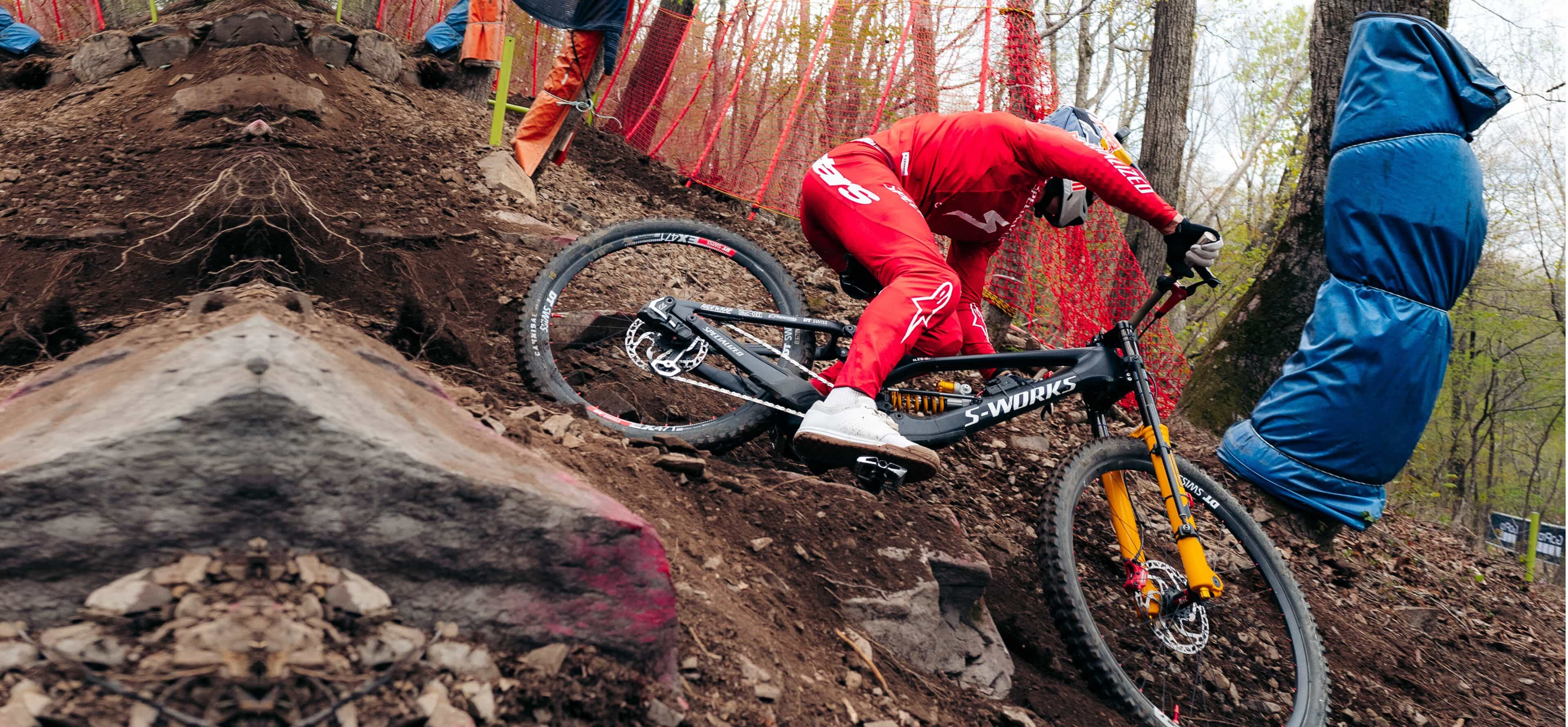 Finn Iles racing a Specialized downhill mountain bike at the UCI Downhill World Cup in South Korea, with a 210 mm BYB Telemetry sensor on the fork and the acquisition unit on the frame.