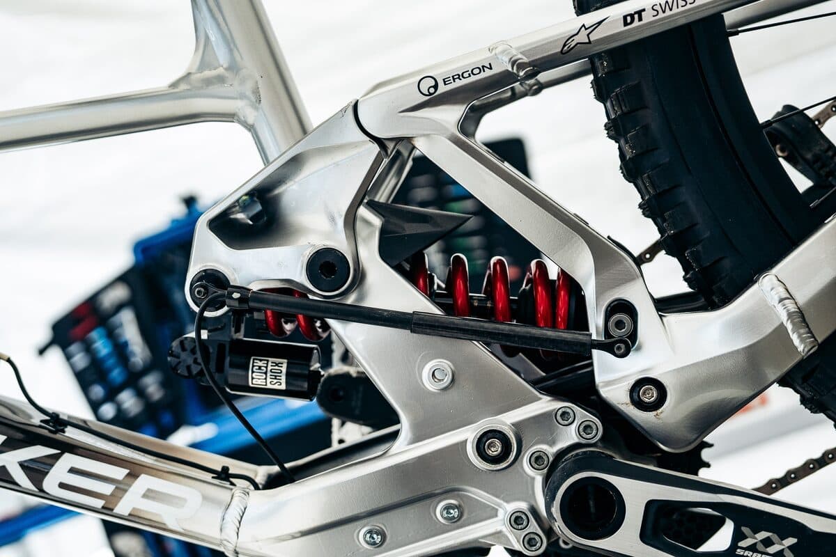 A BYB Telemetry shock sensor fitted diagonally across the coil shock of a downhill mountain bike, between the frame linkage and the lower shock mount.